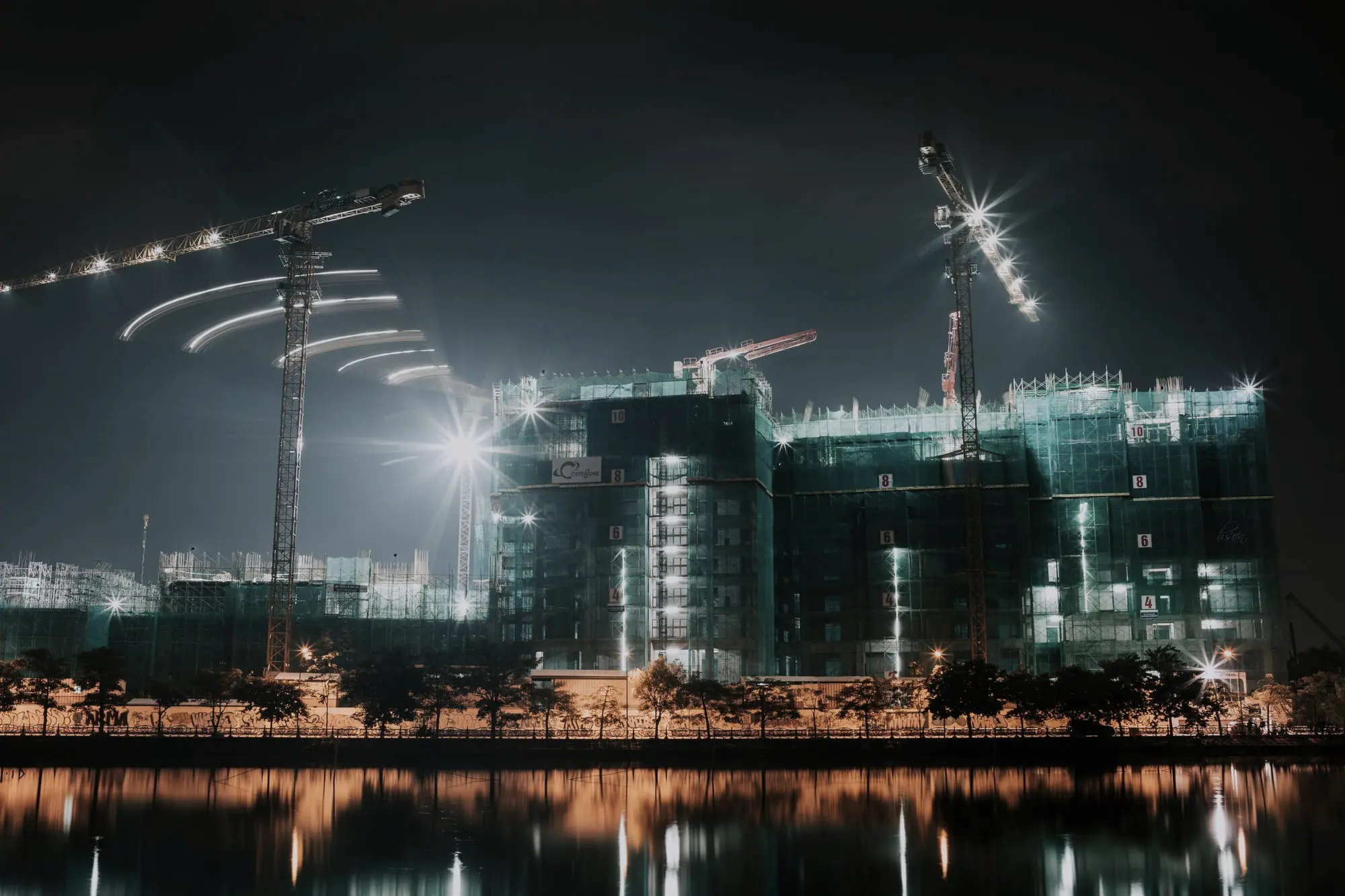 Tower cranes lit against the night sky